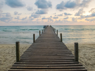 wooden bridge to the sea with twilight sky in the summer time