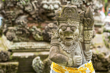 Traditional demon guard statue carved in stone in Bali island, Indonesia.