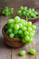 Bunch of green ripe grapes in a wooden bowl