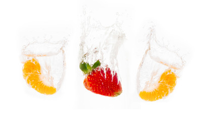 Red strawberry and Orange inside flowing water isolated on white
