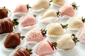 Fototapeta na wymiar Strawberries covered in chocolate on a white wooden table