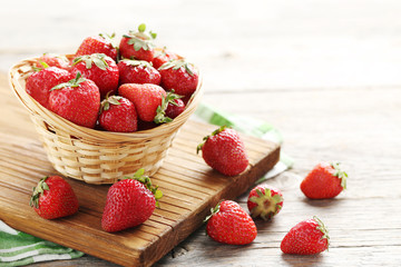 Fresh and tasty strawberries in basket on a grey wooden table