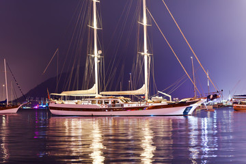 Fototapeta na wymiar Beautiful two-masted yacht moored in the harbor in the evening
