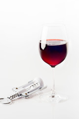 Red Wine and corkscrew  in glass on white background