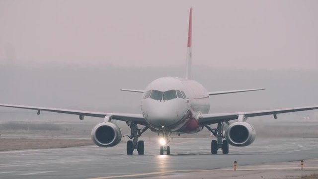 Red Wings airplane turns from runway in the airport.