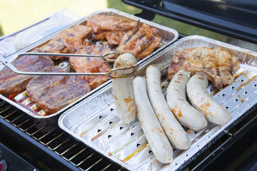 meat and sausages on a grill in summer