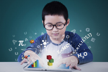 Little boy uses tablet for studying
