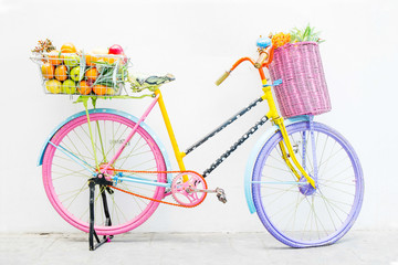 Fototapeta na wymiar Colorful Bicycle carrying flowers parking against the wall