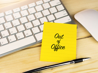 Out of office on sticky note on work desk