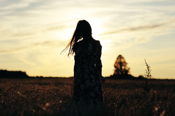 girl in the sunset cloudy sky Field