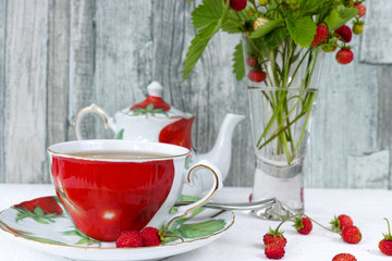 Fresh wild strawberry tea and bouquet of ripe wild strawberries