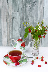 Fresh wild strawberry tea and bouquet of ripe wild strawberries