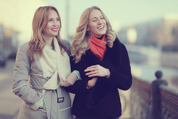 two cheerful blonde for a walk in the city