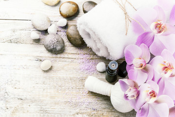 Spa setting with pink orchid, herbal massage ball and essential