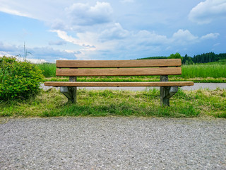 Empty wooden bench on green meadows