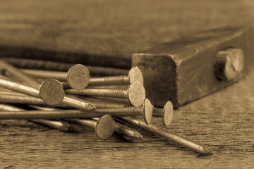 Vintage hammer with nails on wood background