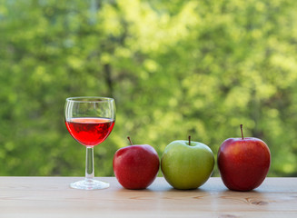 wine glass and colorful apples on table