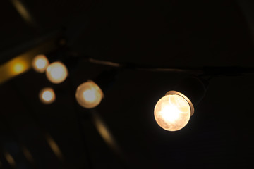 small luminous light bulbs are hanging in dim place.
like found idea from thinking in unclear situation solve the problem or way to be creative and success