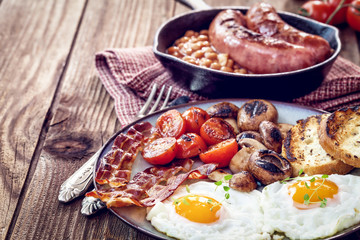 English breakfast with eggs, tomatoes, mushrooms, bacon, beans