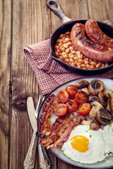English breakfast with eggs, tomatoes, mushrooms, bacon, beans