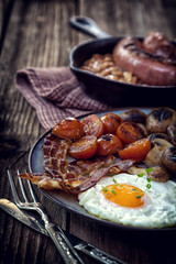English breakfast with eggs, tomatoes, mushrooms, bacon, beans