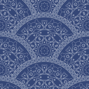 Abstract seamless wavy pattern from decorative ethnic ornaments with dark blue paint texture. Regular fan or peacock tail shaped ornamental elements