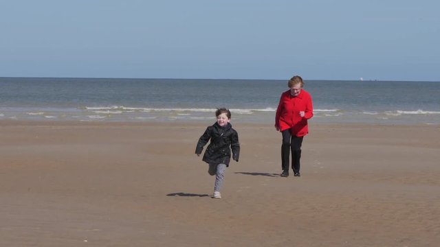 enfant et sa grand mère jouant sur la plage