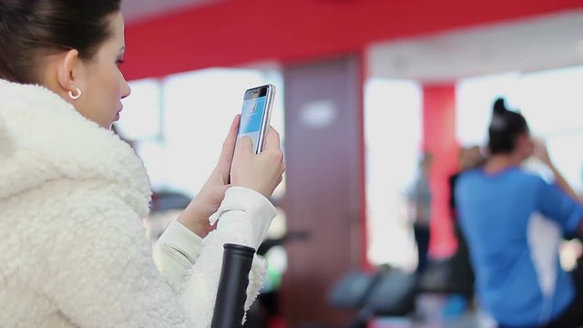 Lazy woman wasting time with smartphone, active lady working out hard in gym