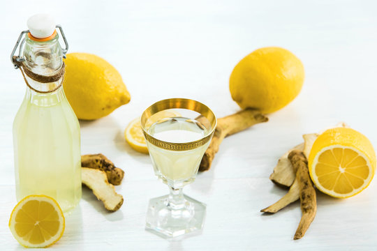 Home Ginger Tincture In A Glass And Fresh Lemons On The White Wooden Background