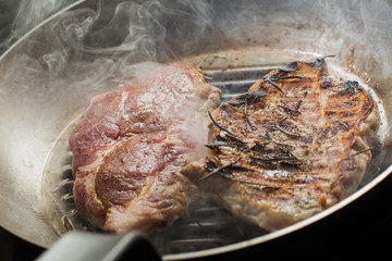 Steak cooking on grille pan. Fresh, delicious, spicy meat on a kitchen with copy space closeup
