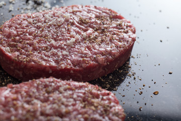 Meat for burgers, grilling, barbecue, bbq. Fresh, spicy, uncooked, delicious beef for hamburgers on dark background with copy space 