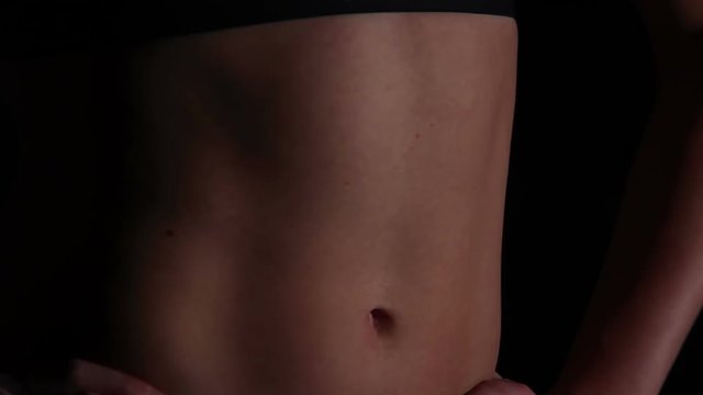 Female athlete boasting of perfect body with ideal flat tummy, healthy diet