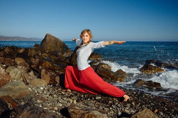 Girl doing yoga. Ocean in background