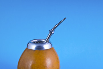 yerba mate with bombilla on blue background