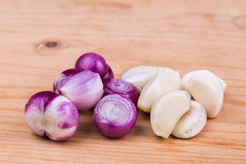 Freshly peeled onion shallots and garlic on wooden table