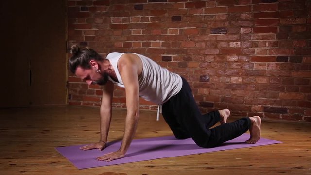 Caucasian man doing yoga exercises in a gym
