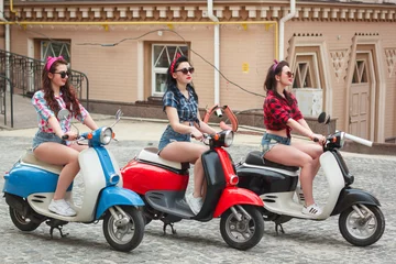 Foto op Plexiglas Three sexy young woman on scooter © nazarets
