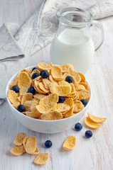 Corn flakes with blueberries and jug of milk