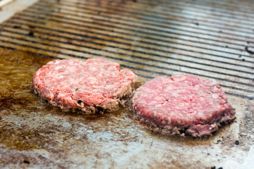 Chef preparing tasty burgers at outdoor stand.