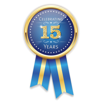 Blue celebrating 15 years badge, rosette with gold border and ribbon