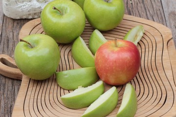 green and red apples on wood background.