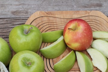 green and red apples on wood background.