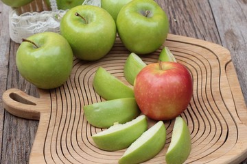green and red apples on wood background.