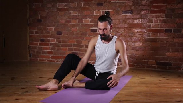 Handsome Caucasian man is engaged in yoga indoors
