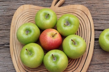 green and red apples on wood background.