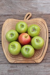 green and red apples on wood background.