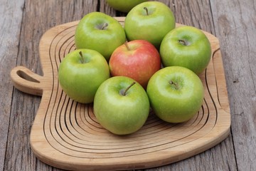 green and red apples on wood background.