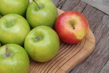 green and red apples on wood background.