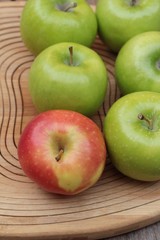 green and red apples on wood background.