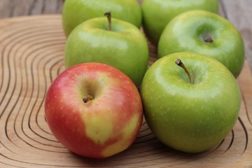 green and red apples on wood background.